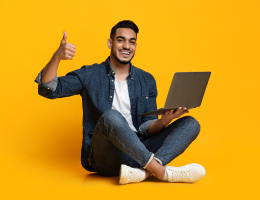 cheerful-arabic-guy-with-laptop-showing-thumb-up-image